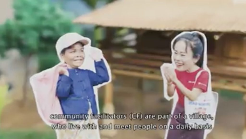Video still of two Lao people in a village greeting each other.